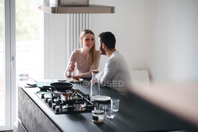 Пара сидящих на кухне в баре для завтрака — стоковое фото