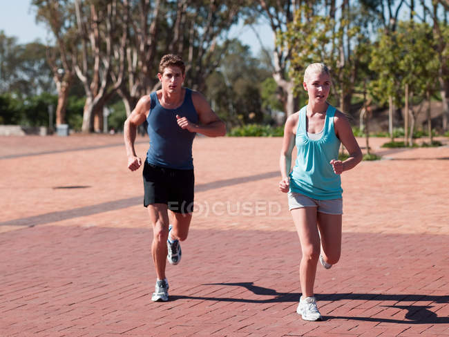 Casal jovem correndo em sportswear ao ar livre durante o dia — Fotografia de Stock