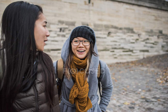 Two young female tourists talking on riverbank, Paris, France — Stock Photo
