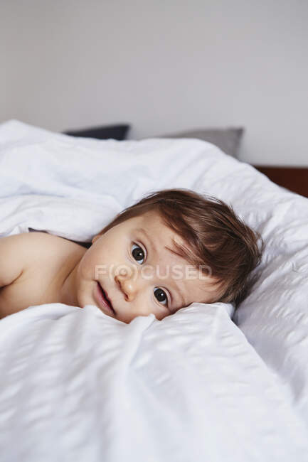 Portrait of baby girl lying on bed — Stock Photo