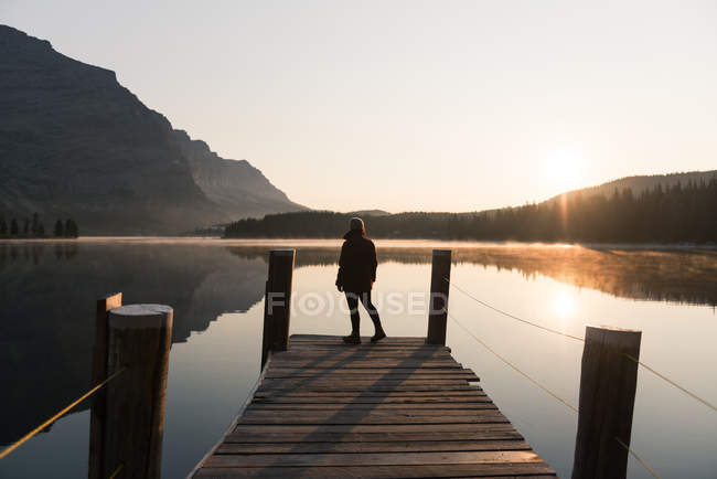 Woman looking at lake on pier, West Glacier, Montana, USA — Stock Photo