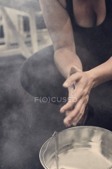 Cropped view of woman rubbing hands in sports chalk — Stock Photo
