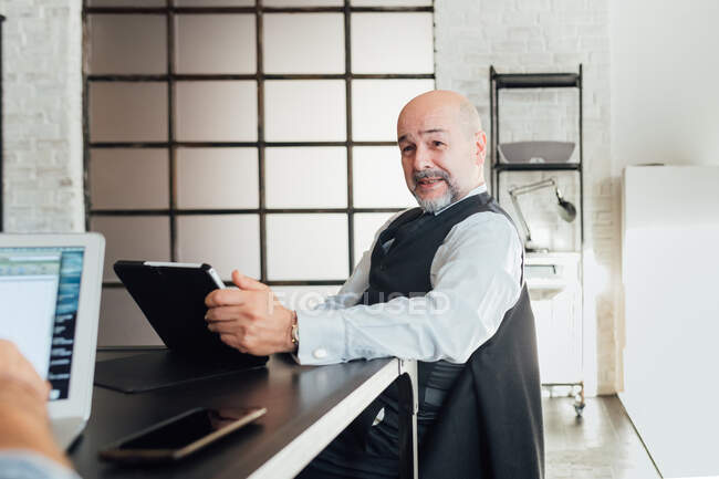 Porträt eines Geschäftsmannes mit digitalem Tablet vor der Kamera — Stockfoto