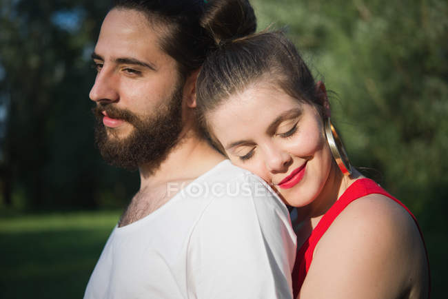 Porträt eines jungen Paares, das sich im Garten umarmt — Stockfoto