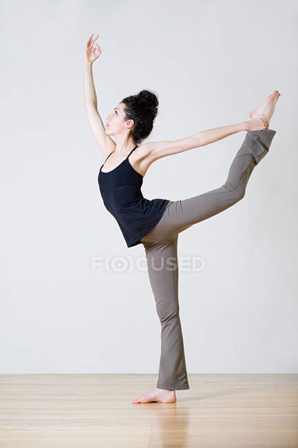 Vista lateral da mulher praticando ioga no estúdio — Fotografia de Stock