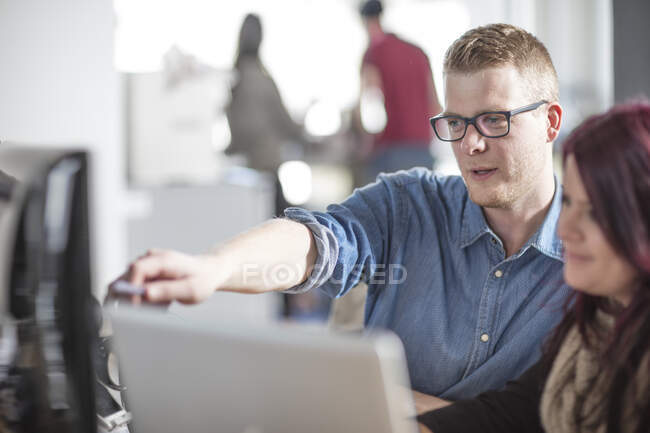 Male and female colleagues working at office computer — Stock Photo