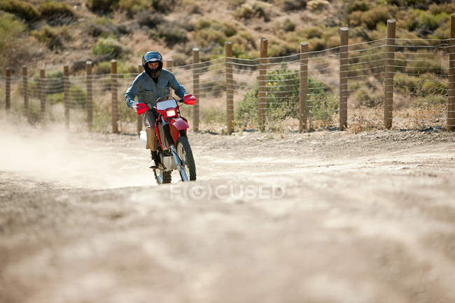 Man riding on dirt bike on dessert track — Stock Photo