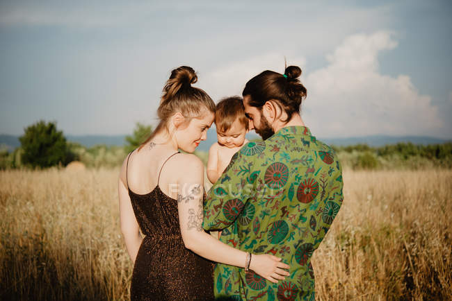 Couple with baby girl on golden grass field, Arezzo, Tuscany, Italy — Stock Photo