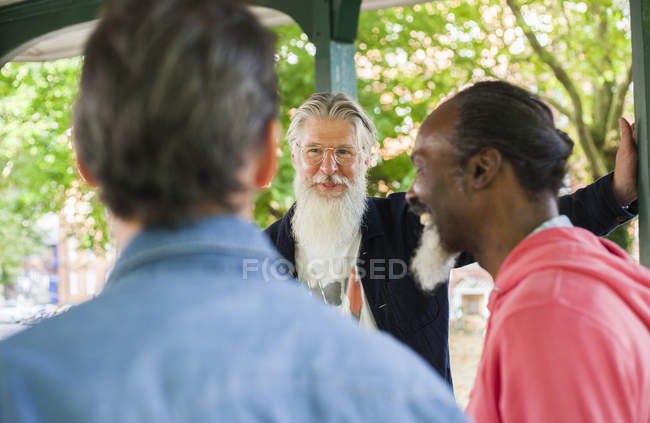 Trois hommes matures debout sous bandstand — Photo de stock