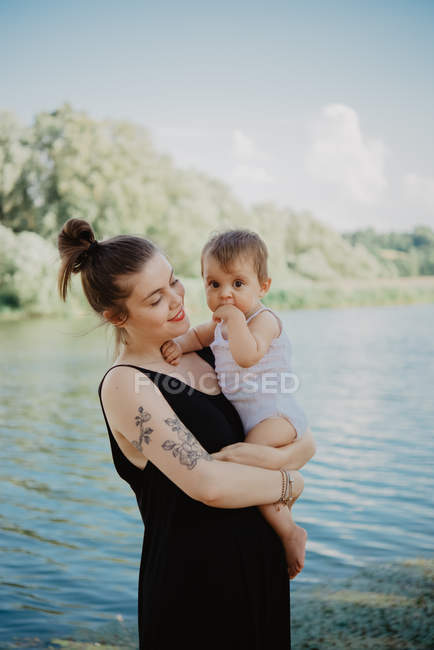 Retrato de la mujer con la niña por el lago, Arezzo, Toscana, Italia - foto de stock