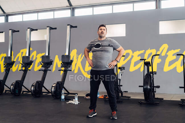 Porträt eines Mannes im Fitnessstudio, Hände auf Hüften, Blick in die Kamera — Stockfoto