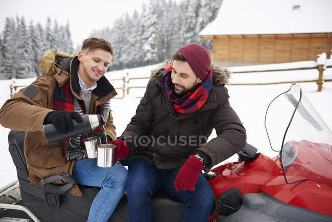 Young men having coffee outdoors in winter — Stock Photo