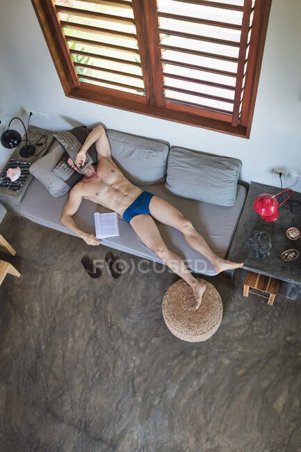 Mature man in underpants asleep on sofa, overhead view — Stock Photo