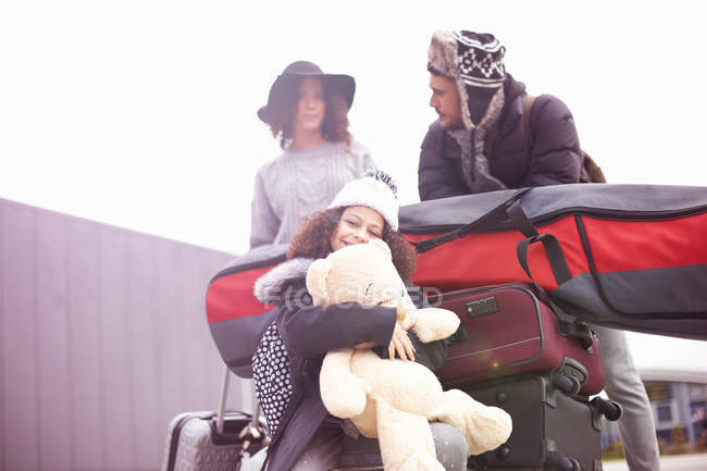 Vista de ángulo bajo de Chica con los padres montando en el carro de equipaje - foto de stock