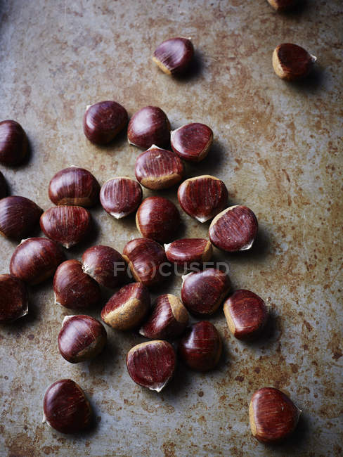 Chestnuts on rustic surface, close-up — Stock Photo
