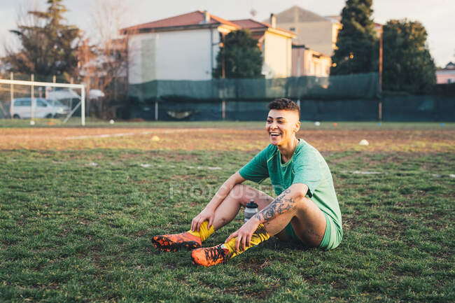 Jugador de fútbol tomando descanso en el campo - foto de stock