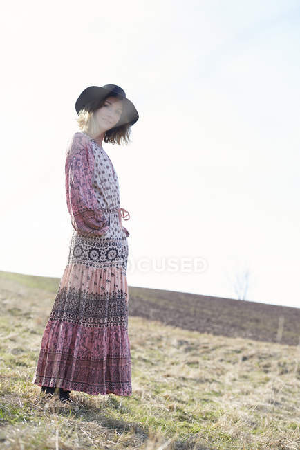 Hippy style woman in felt hat at field — Stock Photo
