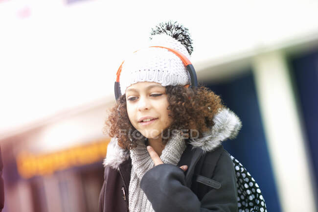 Retrato de menina com cabelo encaracolado usando bobble hat — Fotografia de Stock