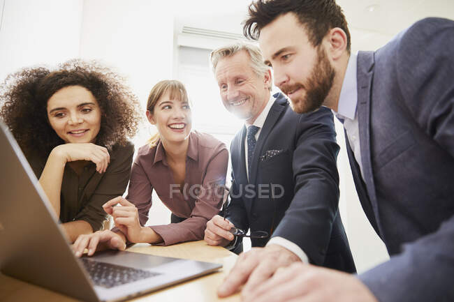 Uomini d'affari in ufficio utilizzando il computer portatile — Foto stock