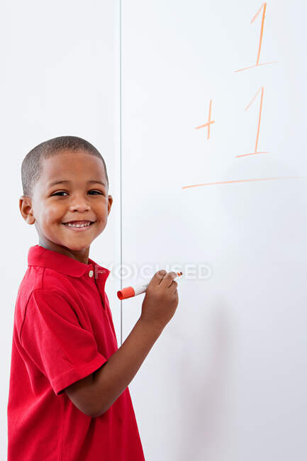 Portrait of Boy with sum on whiteboard — Stock Photo