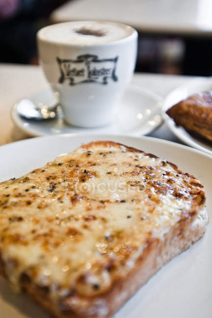 Cooked toast with cheese and cup of coffee on table — Stock Photo
