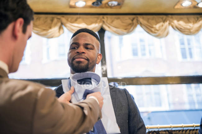 Tailleur coordonnant chemise et cravate pour le client dans le magasin de tailleurs — Photo de stock