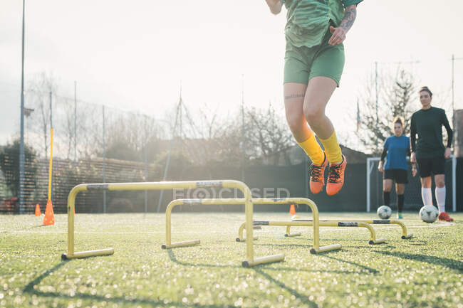Joueur de football sautant par-dessus les obstacles — Photo de stock