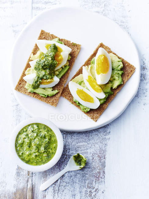 Salsa verde, uova, avocado, cracker di segale — Foto stock