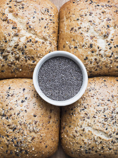 Close up de pães multigrãos com uma tigela de sementes de chia, vista superior — Fotografia de Stock