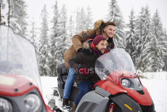 Giovani uomini a cavallo motoslitta in inverno — Foto stock