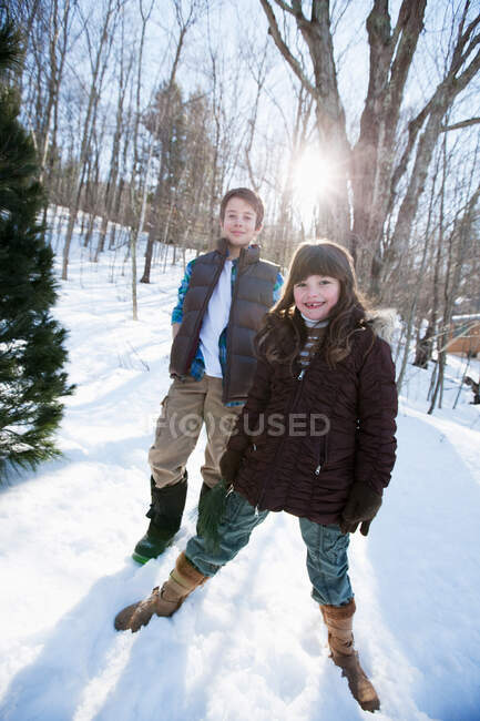 Bruder und Schwester stehen im Schnee, Portrait — Stockfoto