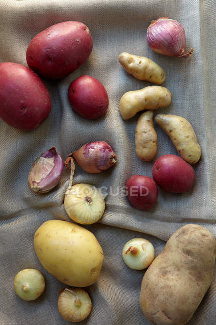 Pommes de terre, échalotes et oignons, nature morte, vue de dessus — Photo de stock