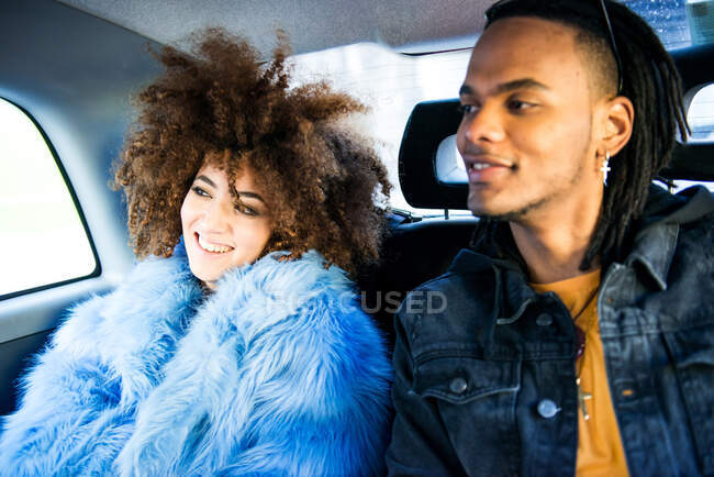 Young man and woman in back of taxi, smiling — Stock Photo