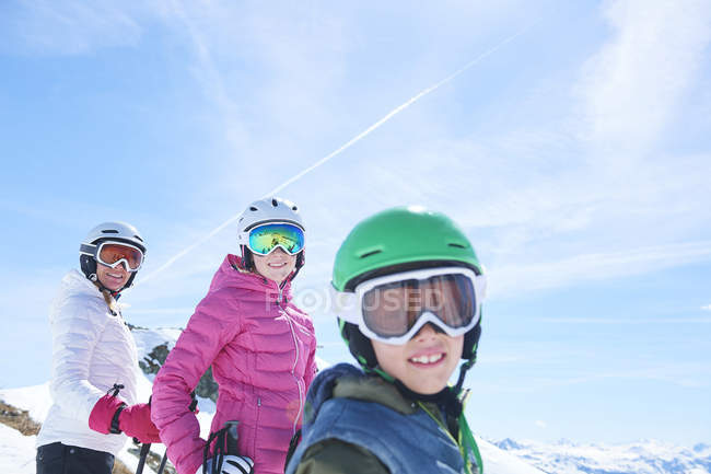 Madre con hija e hijo en vacaciones de esquí sonriendo a la cámara, Hintertux, Tirol, Austria - foto de stock
