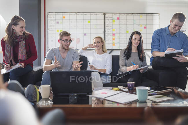 Colegas masculinas e femininas tendo brainstorming reunião no cargo — Fotografia de Stock