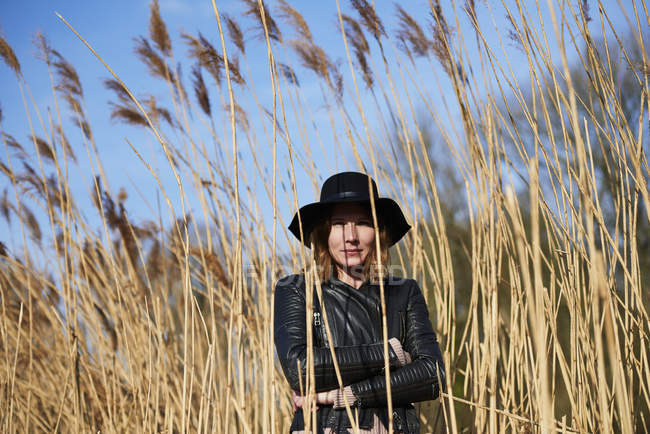 Woman in felt hat standing among reeds — Stock Photo