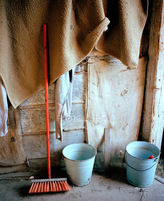 Scopa e secchi in stalla — Foto stock