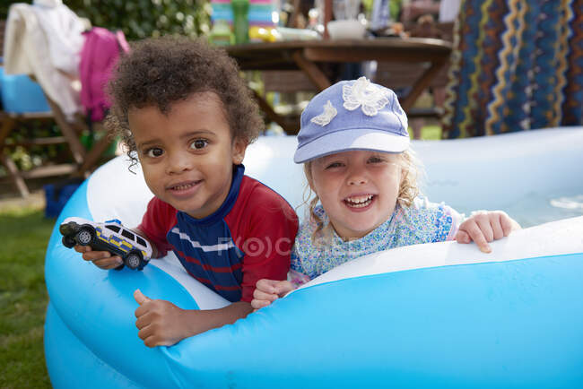 Dos niños jugando en la piscina infantil, retrato - foto de stock