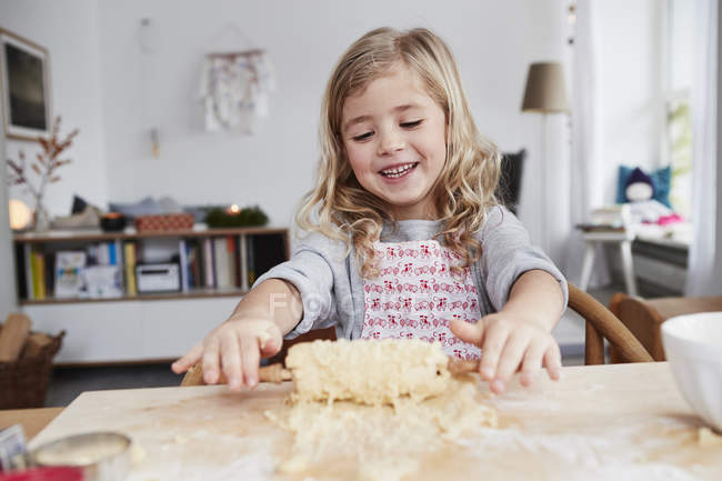 Jeune fille rouler la pâte pour cookie — Photo de stock