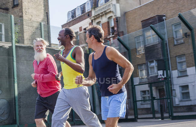 Tre uomini maturi correre all'aperto — Foto stock