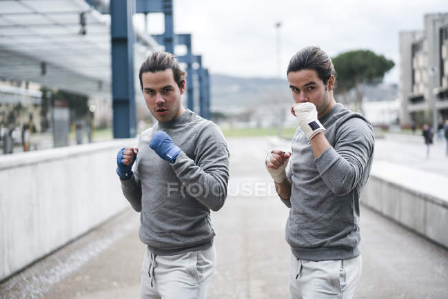 Boxeadores gemelos en posición de lucha al aire libre - foto de stock