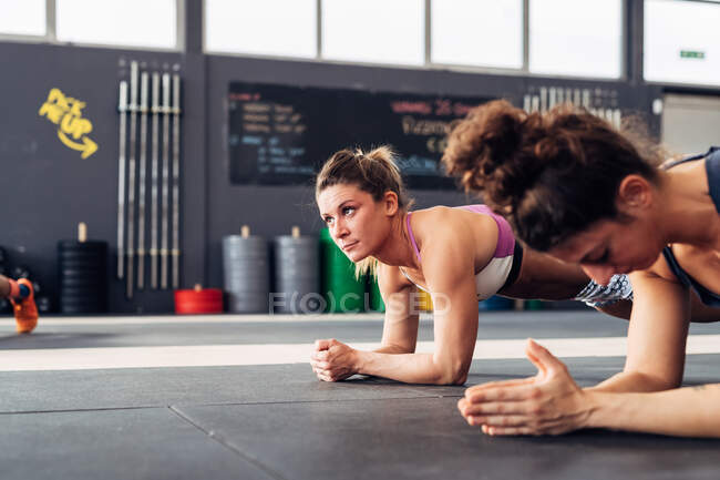 Cropped view of women in gym planking — Stock Photo