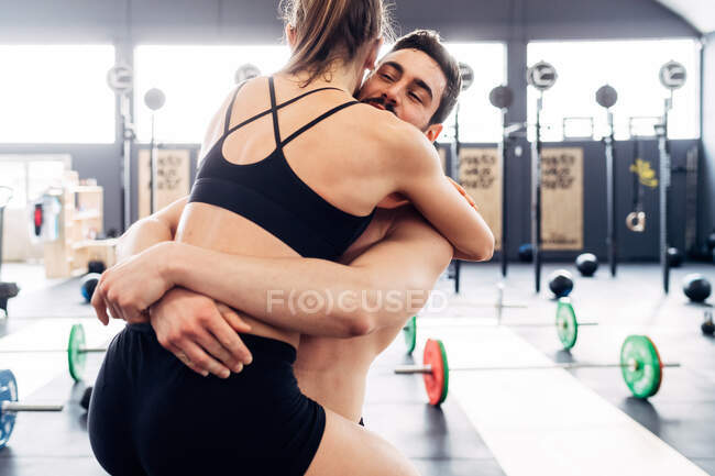 Paar umarmt sich im Fitnessstudio — Stockfoto