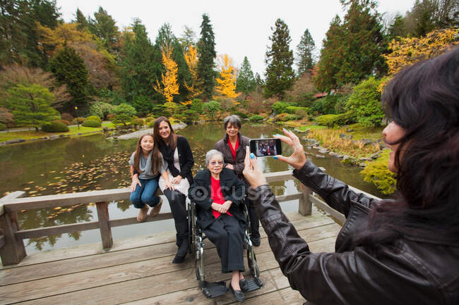 Woman photographing multi generation family — Stock Photo