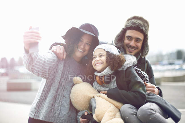 Vista frontal de la sonriente familia tomando selfie - foto de stock