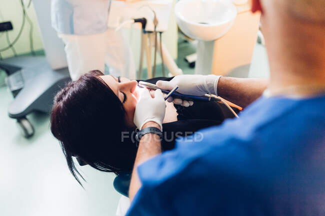 Стоматолог, проводящий стоматологическую процедуру пациентке — стоковое фото