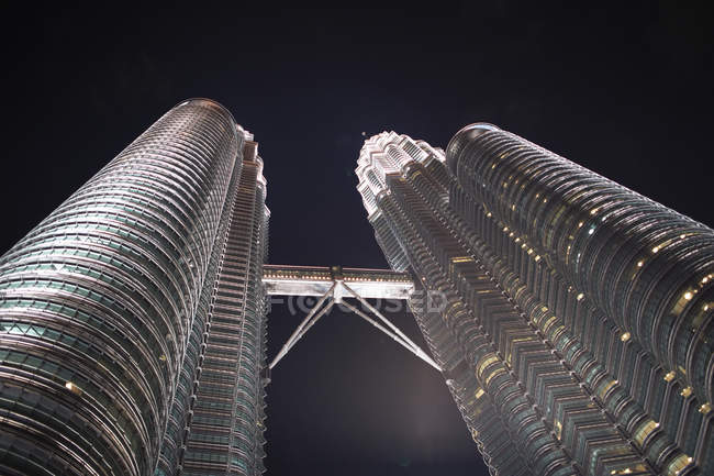 Torres Petronas iluminadas por la noche, vista de bajo ángulo, Kuala Lumpur, Malasia - foto de stock