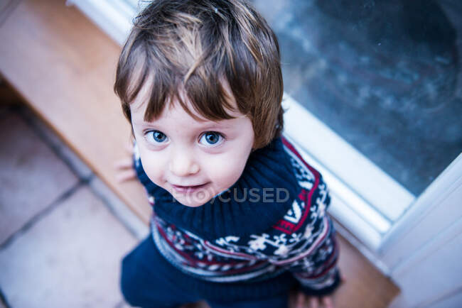 Boy sitting by patio door — Stock Photo