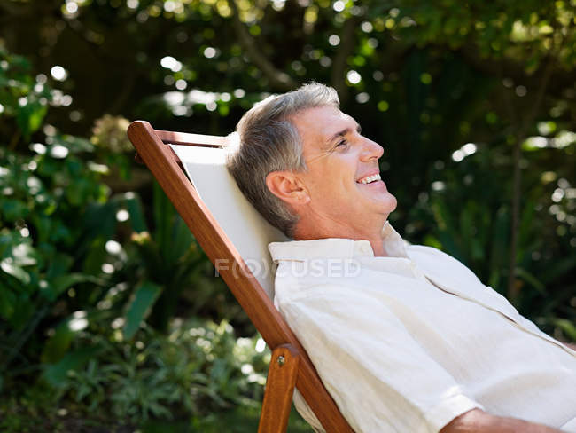 Ritratto di uomo seduto sulla sedia a sdraio — Foto stock