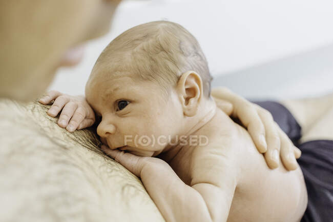 Baby boy lying down on fathers bare chest — Stock Photo